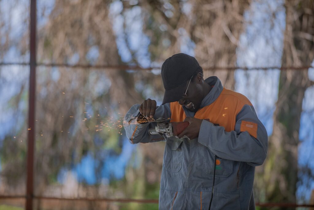 Fabricator grinding steel with an angle grinder