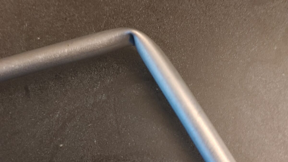 Metal tube with a sharp kink where it collapsed during bending