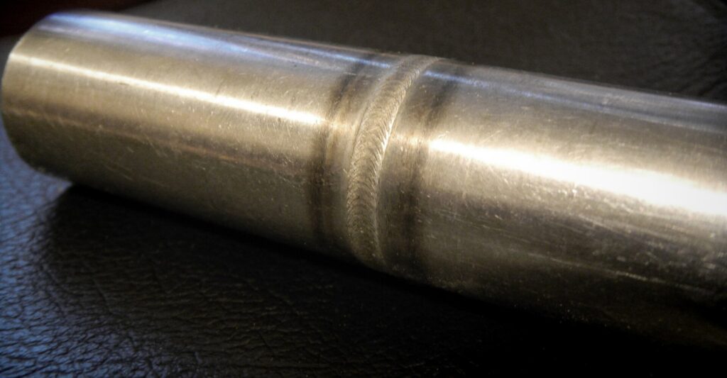 Orbital welding head clamped around a stainless steel tube