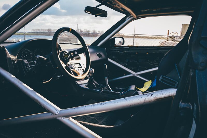 Race car interior with a welded tubular roll cage around the driver's seat